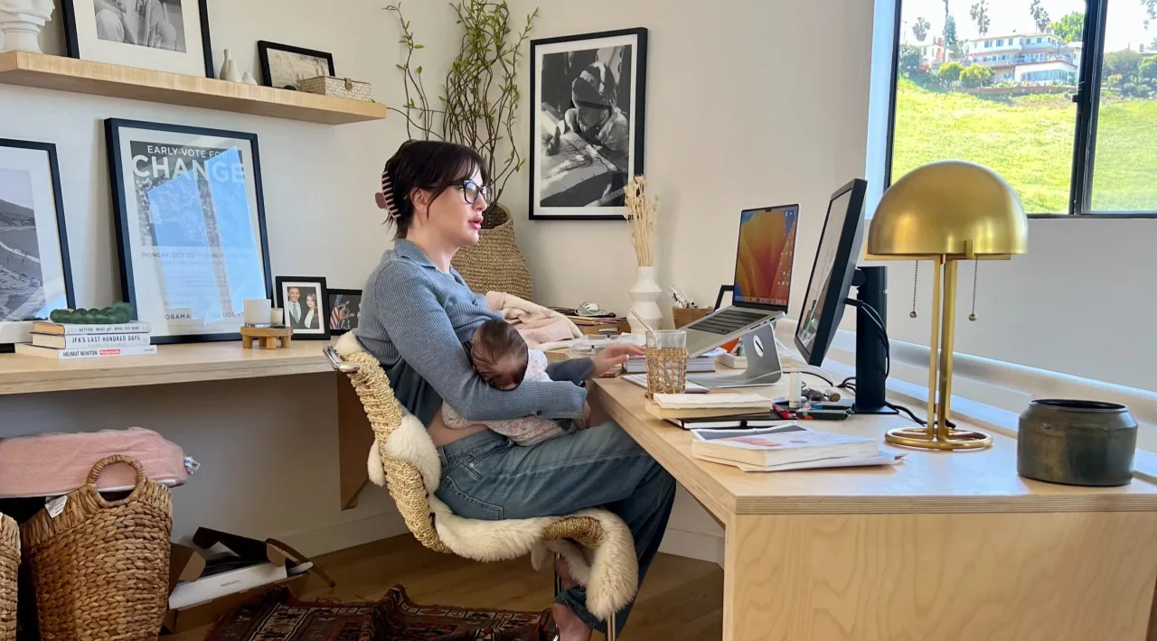 Lisa Conn, CEO of Gatheround, nurses her newborn while leading a team meeting on Gatheround's video meetings platform from Los Angeles, California in March 2023.